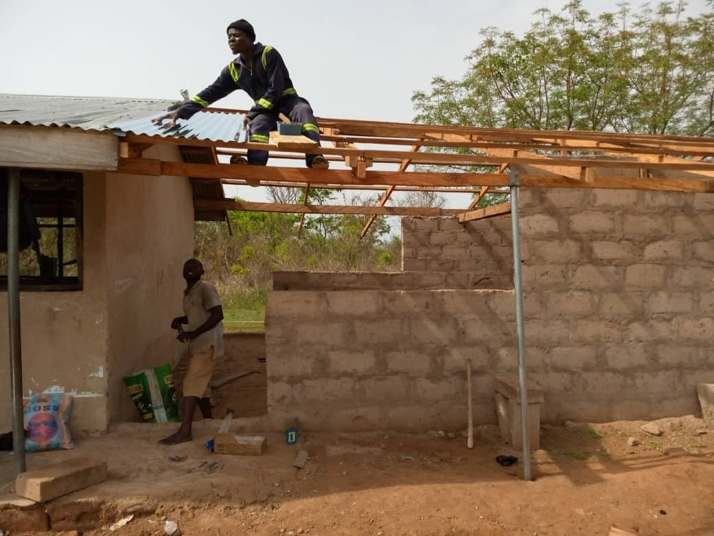 Laying the corrugated roofing sheets.