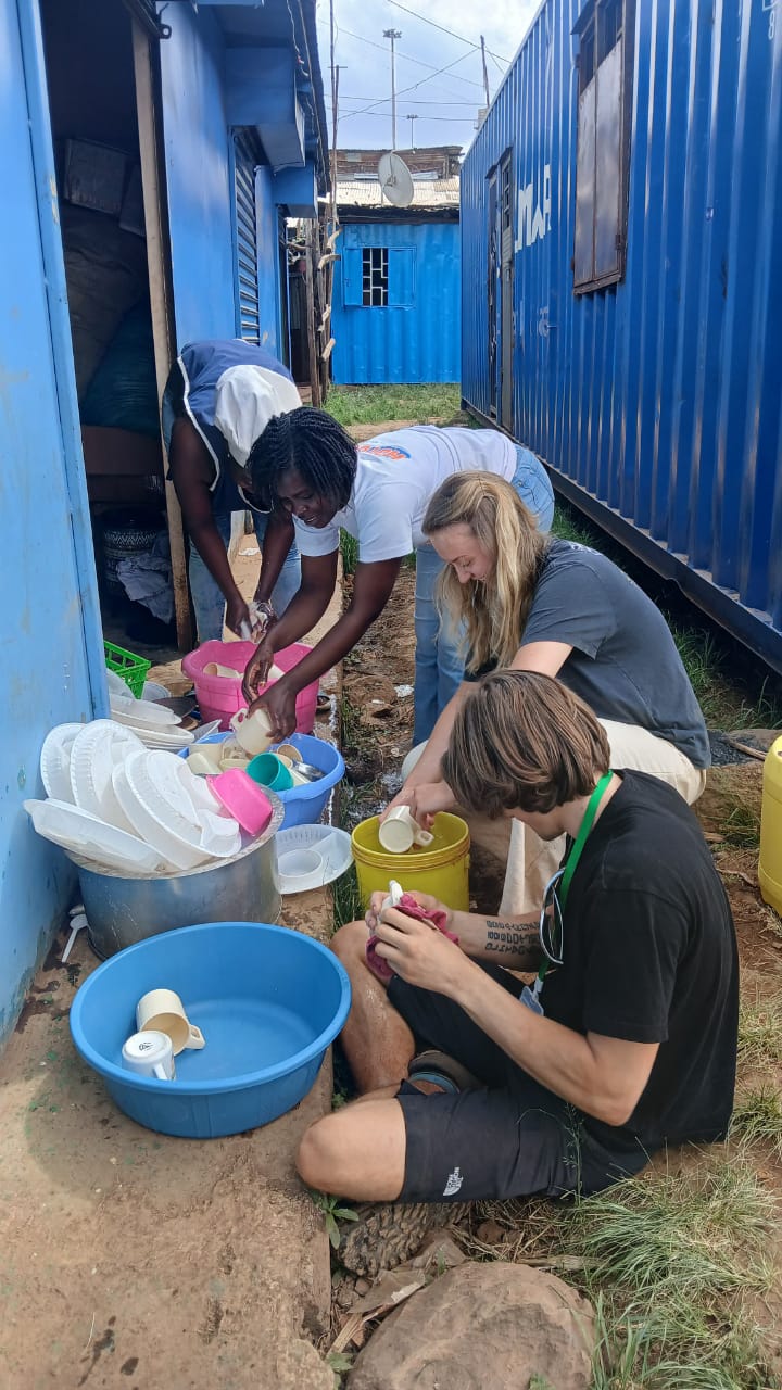 Volunteers helping with lunchtime washing-up at Malaika School, Kibra.